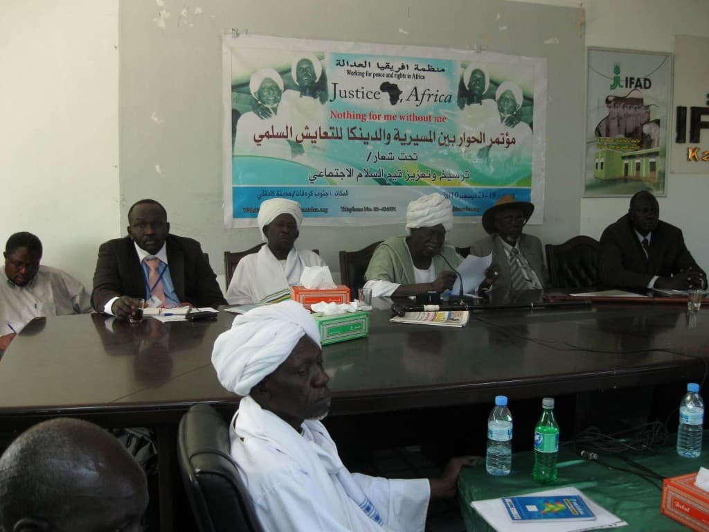 Dialogue conference participants seated around a table in South Kordofan